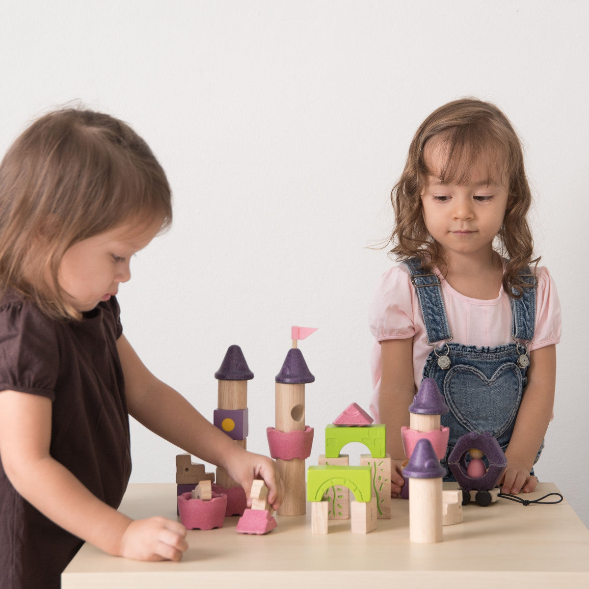twee kinderen stapelen blokken van plantoys